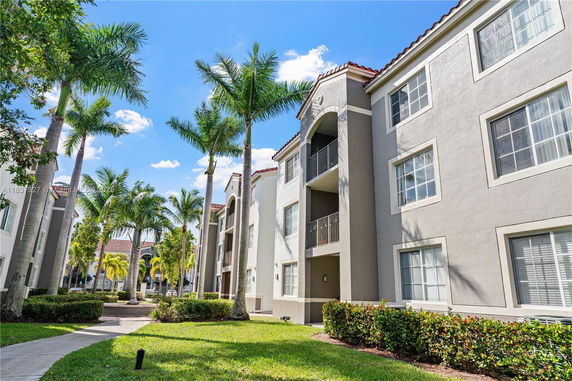Front view of a three-story apartment building with balconies.