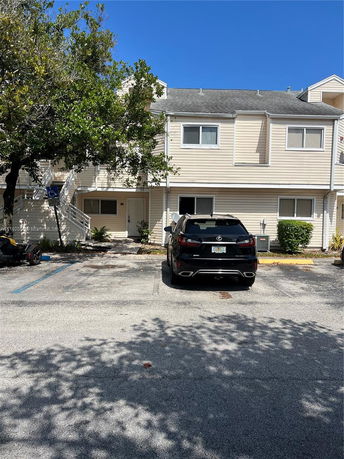 Outdoor parking area in front of a two-story building.