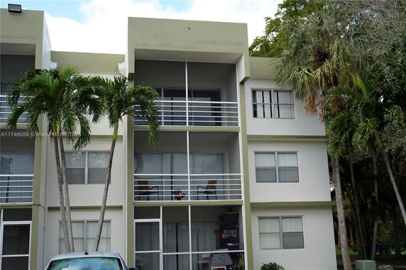 Front view of a three-story apartment building with balconies.
