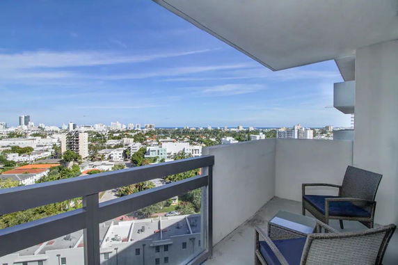 View of the surrounding cityscape from a balcony high above the ground.