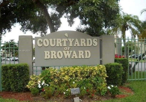 Signage for Courtyards of Broward amidst landscaping and trees.