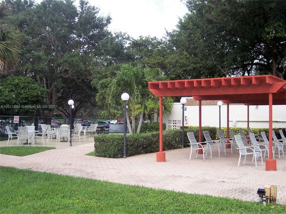 Outdoor area with chairs and a pergola for recreation.