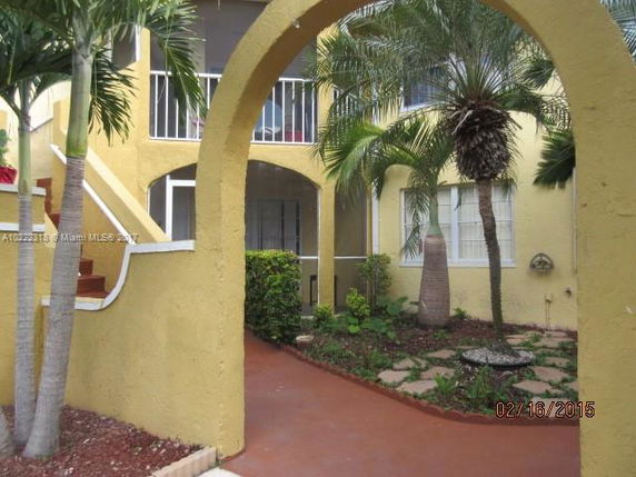 Front view of a building with yellow walls and an archway entrance.
