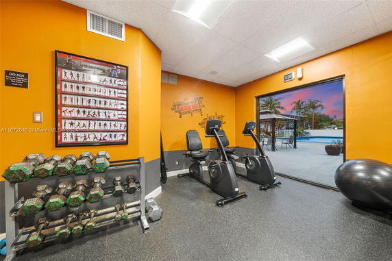 Indoor gym area with equipment and bright orange walls.