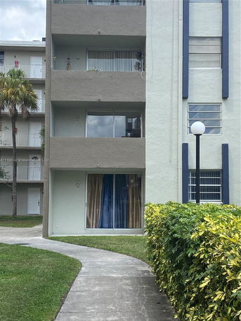 Front view of a multi-story apartment building with balconies.