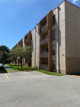 Front view of a multi-story apartment building with balconies.