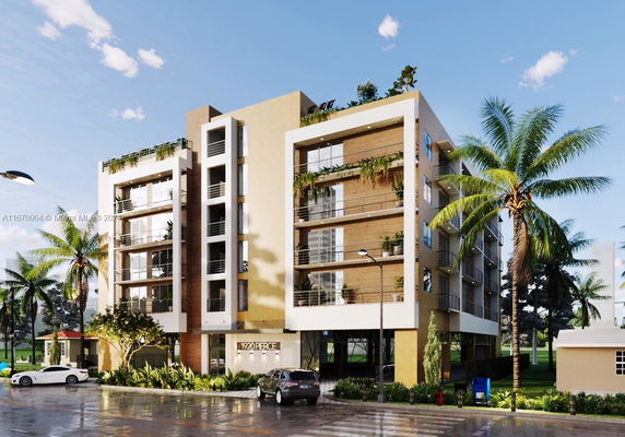 Front view of a modern multi-story residential building with balconies and greenery.