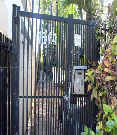Front gate view of a building with an entrance keypad.
