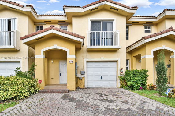 Front view of a two-story house with a garage and balcony.