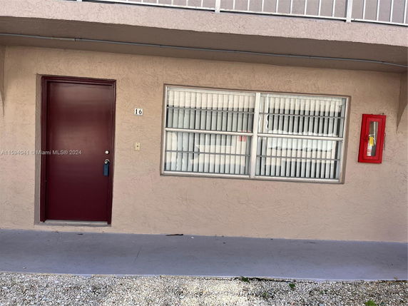 Front view of a building with a single door and large window.