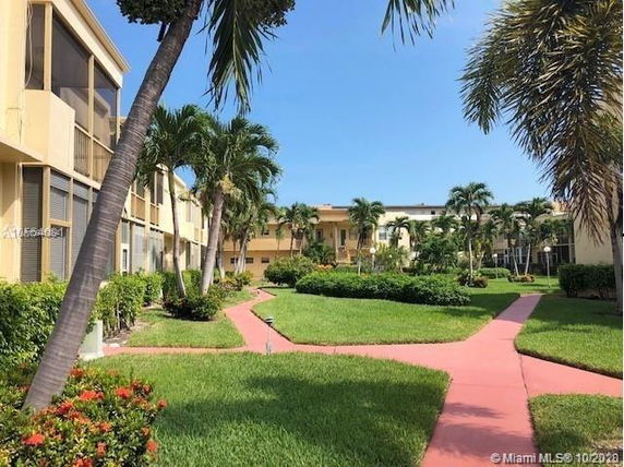 View of surrounding area with pathways and landscaping in front of a residential building.