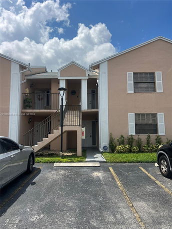 Front view of a two-story residential building with an external staircase.
