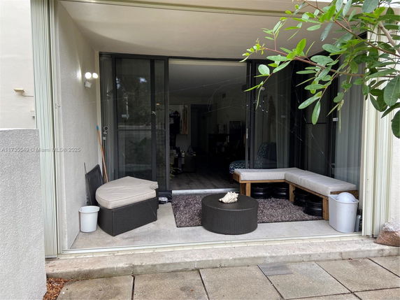 Outdoor seating area adjacent to a building with sliding glass doors.