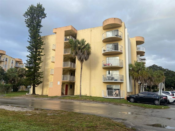 Front view of a multi-story residential building with balconies.