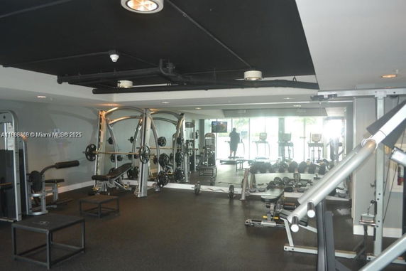 Indoor gym area with exercise equipment and mirrors.