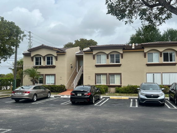 Front view of a two-story residential building with parking spaces
