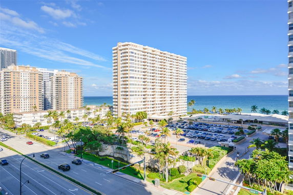 View of tall apartment buildings near the coast with the ocean in the background.