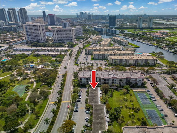 Aerial view of a residential area with high-rise buildings and tennis courts.