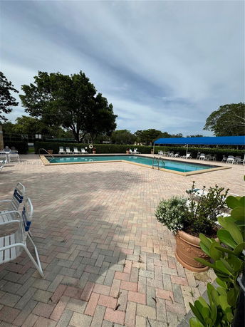 Outdoor swimming pool with surrounding deck and seating.