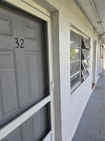 Front view of an apartment door and windows in a concrete building.