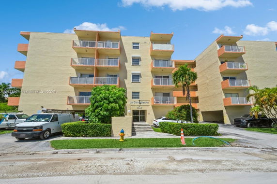 Front view of a multi-story apartment building with balconies.