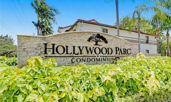 Front view of a condominium building with a prominent entrance sign reading 'Hollywood Parc'.