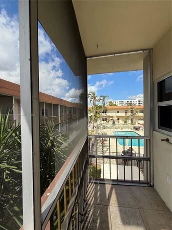 View of a swimming pool area from a covered balcony.