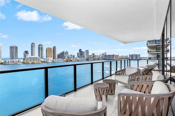 Balcony view overlooking a city skyline across the water.