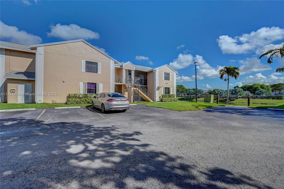 Front view of a two-story residential building with parking area.