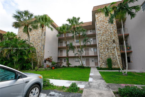 Front view of a multi-story building with stone facade and balconies.