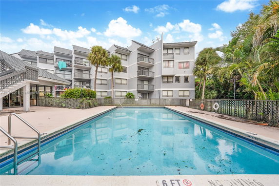 Apartment complex with swimming pool in the foreground.