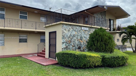 Front view of a two-story building with stonework and a balcony.