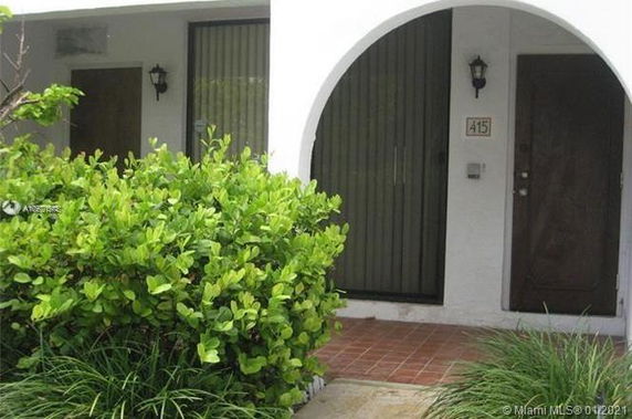 Front view of a building with an arched entrance and a wooden door.