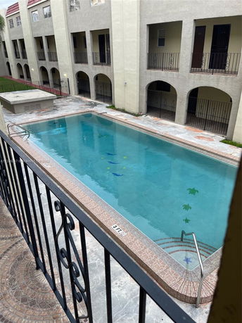Outdoor swimming pool area with apartment balconies.