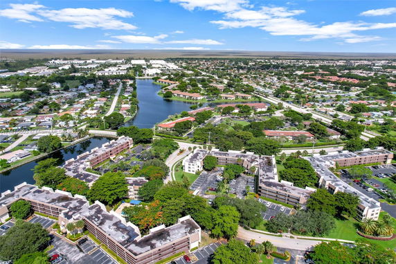 Aerial view of residential and green areas with a water body running through the community.
