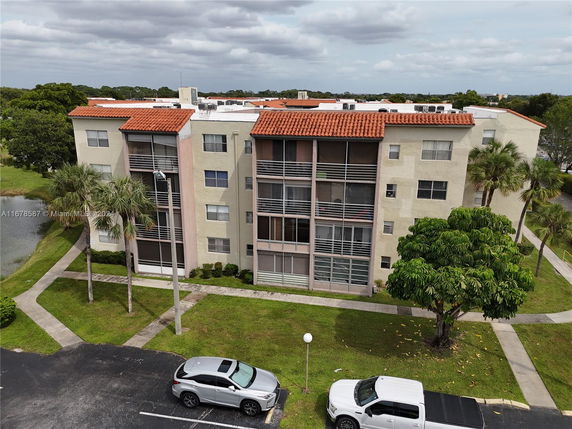 Front view of a three-story apartment building with balconies and red-tiled roof.
