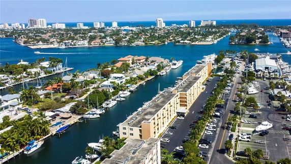 Aerial view of buildings and waterways with boats in a coastal city.