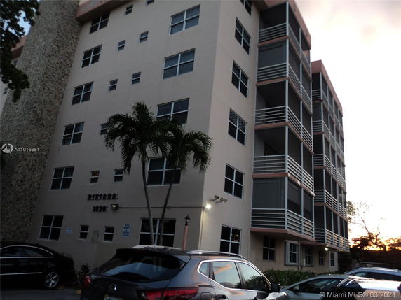 Front view of a multi-story apartment building with balconies.