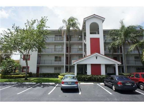 Front view of a multi-story residential building with balconies and a central entrance.