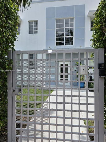 Front view of a building with a gated entrance and multiple windows.