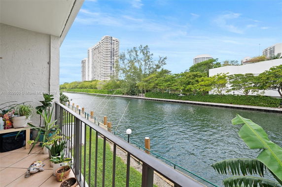 View from a balcony overlooking a river with tall buildings in the background.