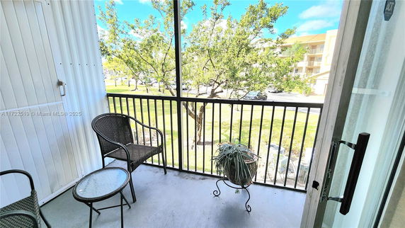 Balcony view overlooking surrounding buildings and trees.