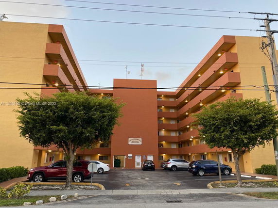 Front view of a multi-story apartment building with balconies.