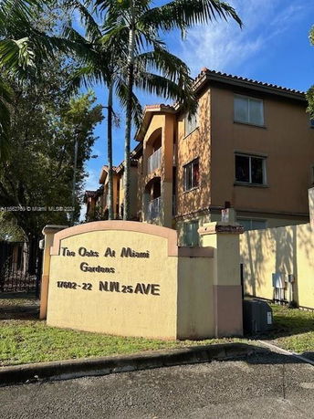 Front view of a multi-story apartment building with a sign reading 'The Oaks At Miami Gardens'.