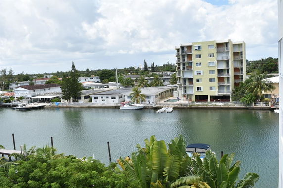 View of a waterway with residential buildings and boats docked along the shore.