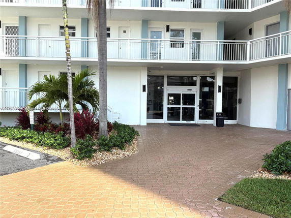 Front view of a multi-story building with balconies and entrance.