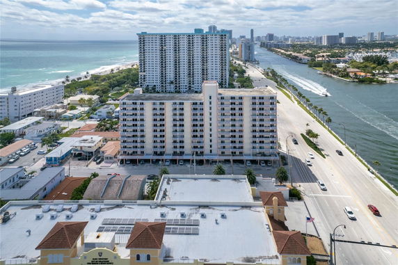 Aerial view of a coastal cityscape with high-rise buildings and nearby water bodies.