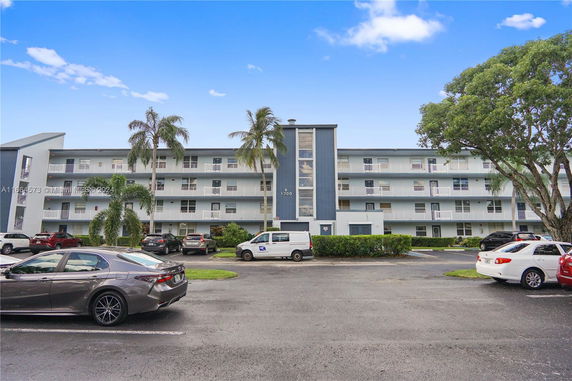 Front view of a multi-story apartment building with balconies.