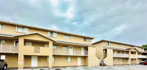 Front view of a multi-story residential building with balconies.