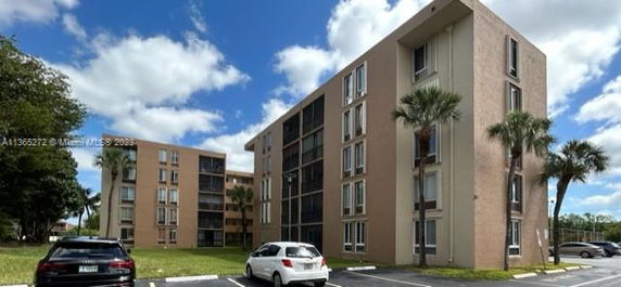 Front view of multi-story apartment buildings with parking area.